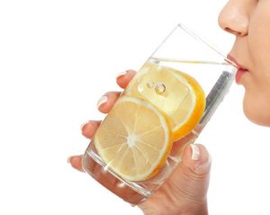 Woman drinking water with lemon